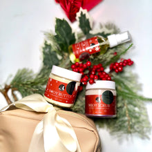 Two jars of body products with a Christmas wreath in the background